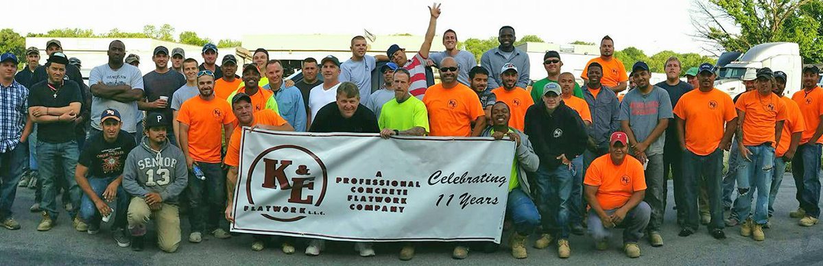 Ke flatwork company photo while holding banner