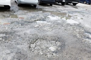 A damaged spalled concrete parking lot