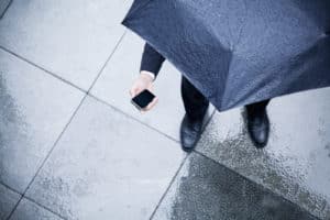 Rain-on-sidewalk-man-with-umbrella