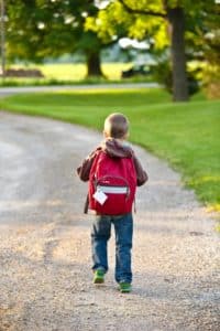 Boy walking in a school sidewalk